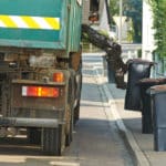 urban municipal recycling garbage collector truck loading waste and trash bin
