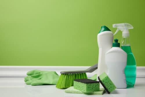 Gloves, cleaning brush, sponge and cleaning supplies on a counter